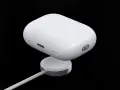 Białe etui AirPods na ładowarce bezprzewodowej.