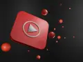 Czerwony przycisk play YouTube z unoszącymi się czerwonymi kulkami na czarnym tle.