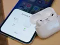 iPhone z otwartym etui AirPods Pro, pokazującym stan naładowania słuchawek.