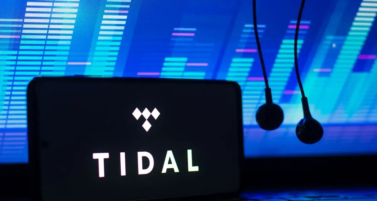 Smartfon z logo TIDAL i słuchawkami na tle ekranu z wizualizacją dźwięku.