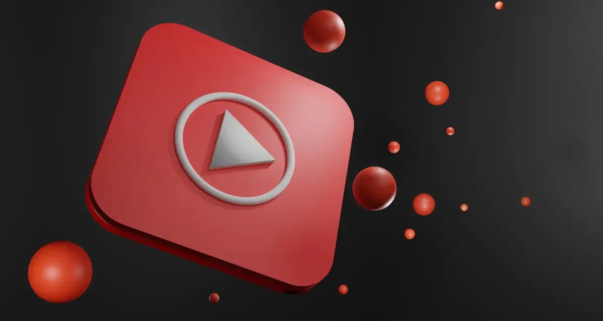 Czerwony przycisk play YouTube z unoszącymi się czerwonymi kulkami na czarnym tle.