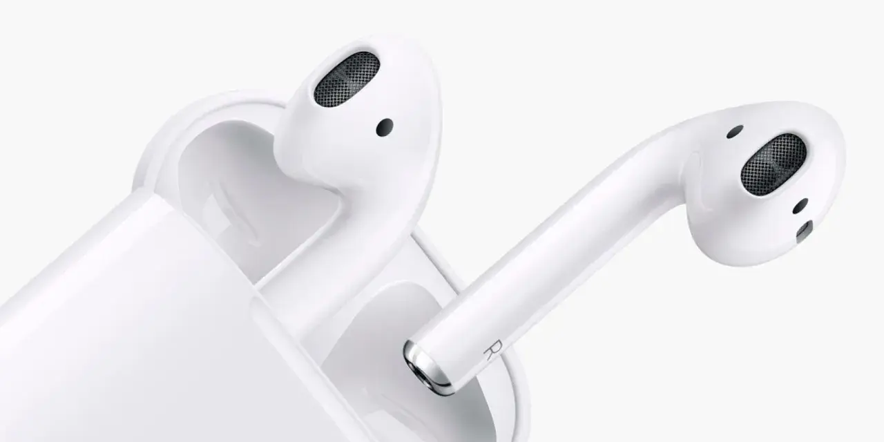 Białe słuchawki AirPods z etui ładującym na białym tle.