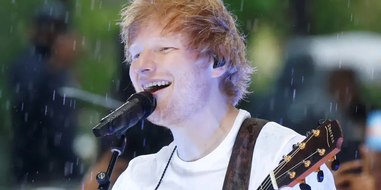 Ed Sheeran grający na gitarze podczas deszczu.