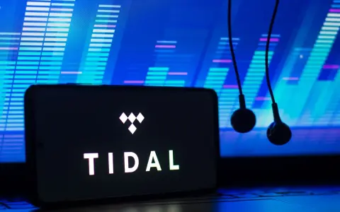 Smartfon z logo TIDAL i słuchawkami na tle ekranu z wizualizacją dźwięku.