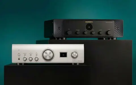 Dwa amplitunery: srebrny Denon i czarny Marantz, ustawione na czarnych podstawkach.