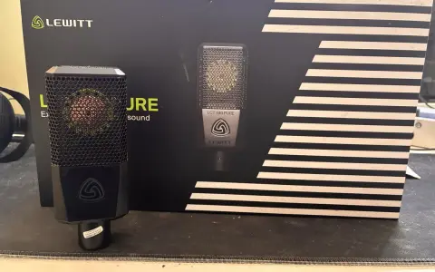 Mikrofon Lewitt LCT 440 PURE na tle czarnego pudełka z białymi paskami.