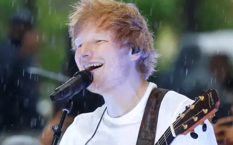 Ed Sheeran grający na gitarze podczas deszczu.