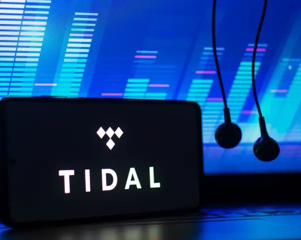 Smartfon z logo TIDAL i słuchawkami na tle ekranu z wizualizacją dźwięku.