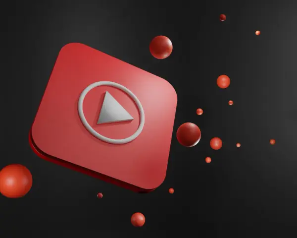 Czerwony przycisk play YouTube z unoszącymi się czerwonymi kulkami na czarnym tle.