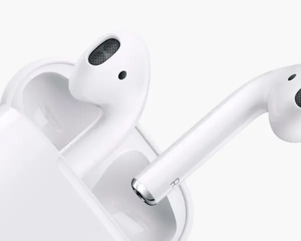 Białe słuchawki AirPods z etui ładującym na białym tle.