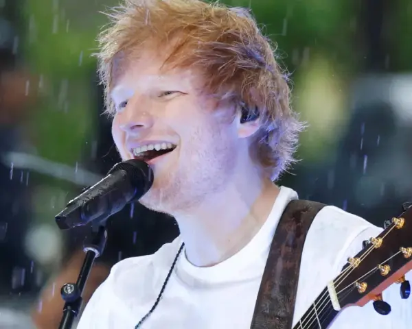 Ed Sheeran grający na gitarze podczas deszczu.