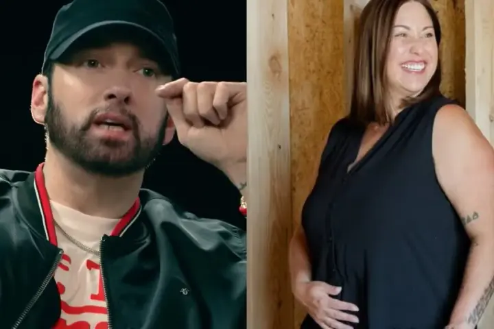 Eminem w czapce i czarnej kurtce obok uśmiechniętej kobiety w czarnej bluzce.